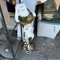 Full view of damaged female statue on base