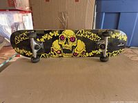 Full view of skateboard underside showing graphic, trucks, wheels