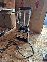 Full view of blender with glass pitcher, chrome base and power cord