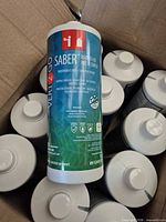 Open box containing multiple white-capped Saber disinfectant bottles