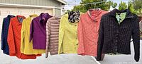 All eight jackets hanging outdoors side by side