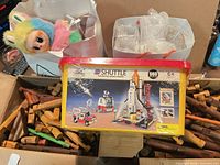 Yellow tub 660-piece Shuttle Launch Center set atop wooden logs and plush visible