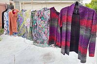 Full row of six garments hanging: jacket, four blouses, cardigan