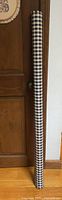 Full view of rolled gingham fabric standing upright
