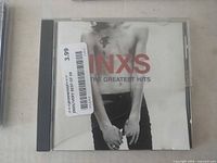 Front of jewel case showing album cover and price sticker, crack visible