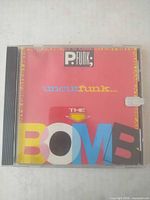 Front view of jewel case showing album cover and sticker