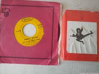 Front view showing 45 RPM single in sleeve and 8-track cartridge