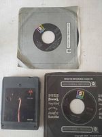 Top view of grey-sleeved single, Aja 8-track, and black-sleeved single showing general condition