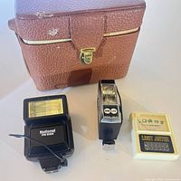 Group shot of both flashes, light meter and camera case