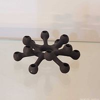 Top/angled view of cast iron spider candle holder showing nine taper sockets