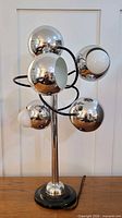 Full view of lamp unlit showing five chrome eyeball shades on central column with black base