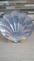 Front view of light blue iridescent shell plate on display stand