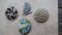All four brooches together for scale and style comparison