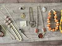 Full lot overview with necklaces, bracelets, brooch and pendants on board