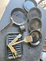 Entire set on table: pan, plates, mug, drip tray, spatula, folding utensil