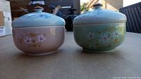 Front view of both lidded bowls showing colors and floral design