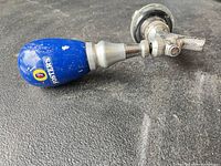 Overall view of tap handle attached to faucet assembly lying on surface