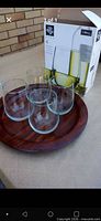 Four stemless wine glasses on wooden tray with Libbey box