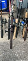 Cluster of rods with attached spinning reels, showing handles and reel seats