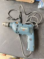 Left side of blue Mastercraft corded drill showing keyed chuck, trigger and cord