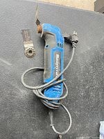 Tool with cord, installed blade, loose blade accessory