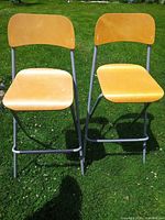 Front view of both folding stools showing seat, backrest, and frame