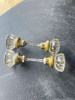 pair of clear glass door knobs joined by spindle