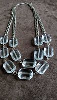Full view of double-strand lucite bead necklace on brown background
