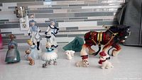 Group shot showing all figurines and glass piece