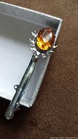 Mizpah kilt pin front view showing amber glass and stag head