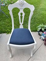 Front view of white carved dining chair with navy upholstered seat