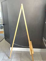 Front view of full wooden A-frame easel standing on floor