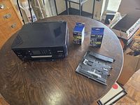 Printer, two sealed ink cartridges, and tray on table