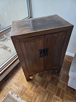 front view of wood cabinet with oriental latch