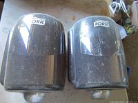 Front view of both Tork towel dispensers showing brand logo and condition