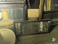small wide rectangular mirror in dark wood frame leaning on floor
