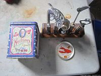 Neilson’s tin, round lobster tin and bar tool set on table