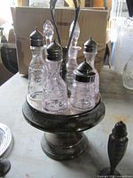 Silverplate castor stand with five cruets on pedestal