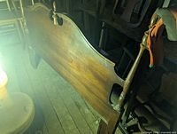 Dark-stained wooden headboard with spindle posts and curved crest rail