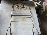 Brass-tone metal rack showing scroll top and horizontal bars