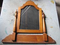 front of wooden mirror frame, glass missing