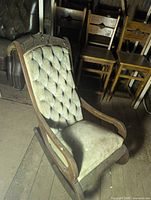 Front angled view showing full rocker, tufted back, wood frame