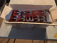 Open shipping box showing multiple red-sleeve blade packs