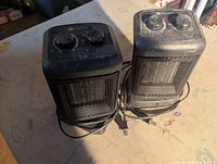 Front view of both Utilitech black oscillating ceramic heaters showing dials, grilles and cords