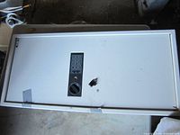 Full view of Barska electronic safe door showing keypad, knob, key, hole, tape