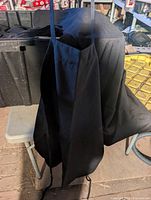 Apron hanging from edge of bin showing neck loop and full length