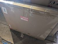 sealed cardboard box containing mirror, fragile sticker visible