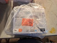 Front of sealed Commercial Electric LED Spin Light box showing branding, size, and product name