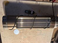 Front view of UFO heater with power cord and remote control displayed