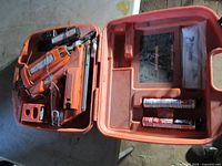 Open Paslode case showing nailer, batteries, charger, fuel cells